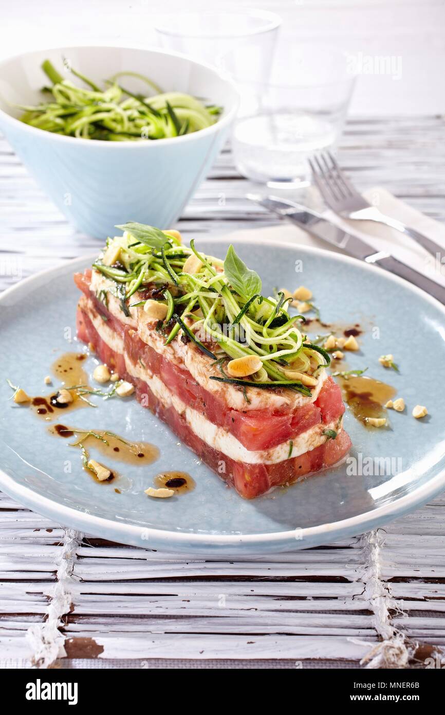 Red and white vegetable terrine with mozzarella, courgette pasta and basil Stock Photo