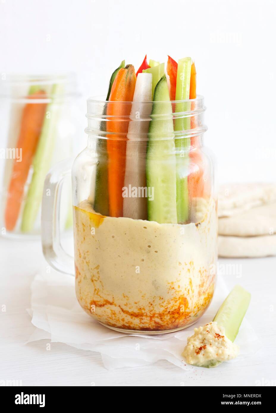 Vegetable sticks in a glass jar with houmous Stock Photo
