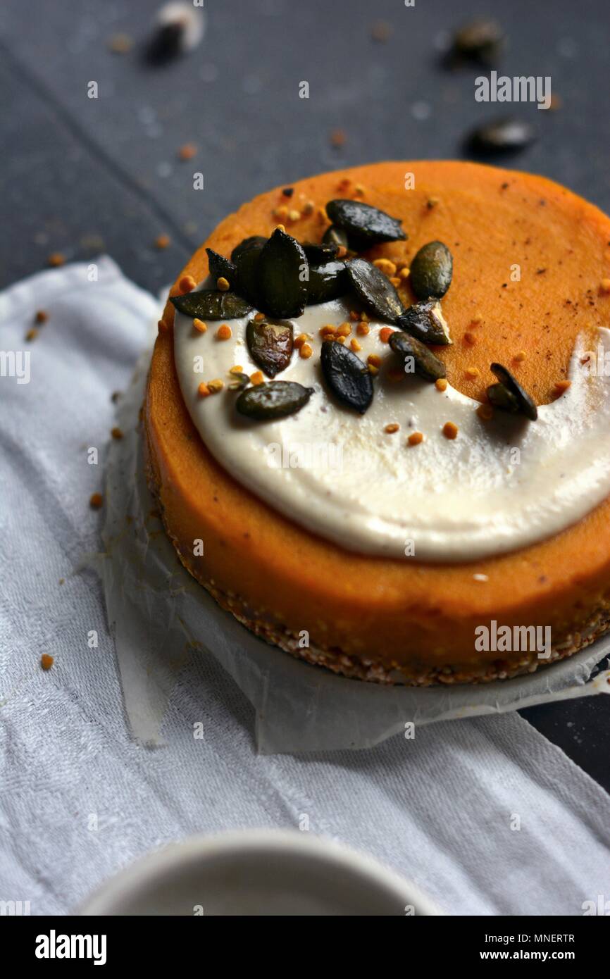 Vegan pumpkin cake with cashew cream and caramelised pumpkin seeds Stock Photo
