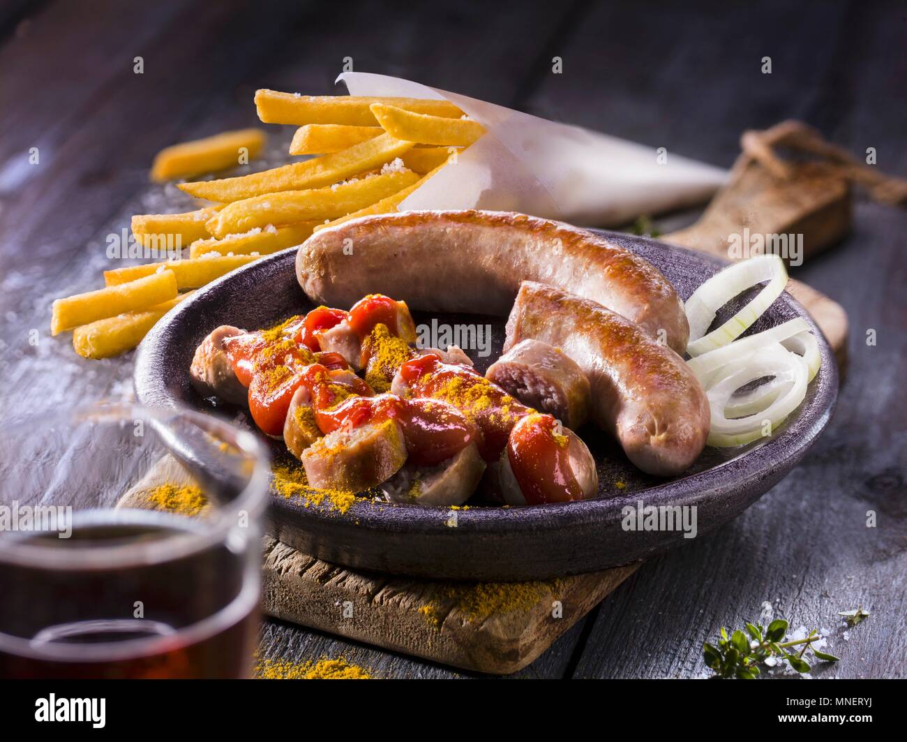 Curry sausages with fries and onion rings Stock Photo