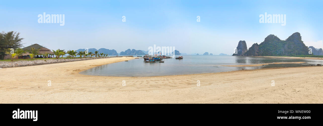 Halong Bay coastal view, Vietnam, bright sun with fishing boats. Stock Photo