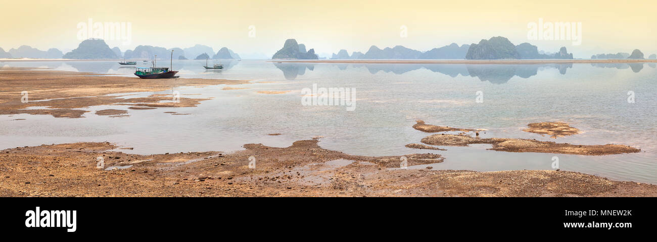 Halong Bay coastal view, Vietnam, fishing boats, sea reflections. Stock Photo