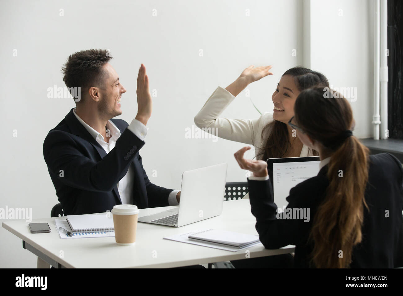 Colleagues giving high five celebrating shared success Stock Photo - Alamy