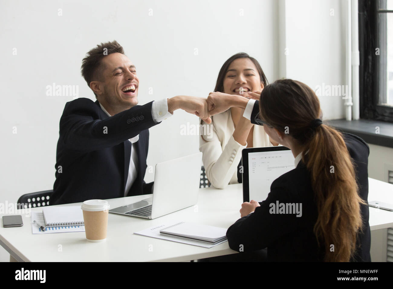 Excited colleagues giving fists bump celebrating success Stock Photo