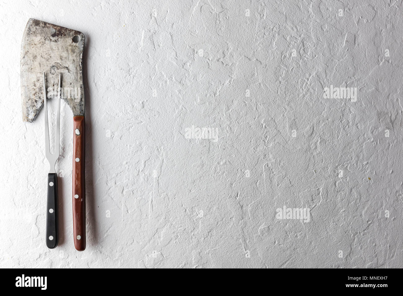 Old rustic axe for meat on a wooden board Stock Photo