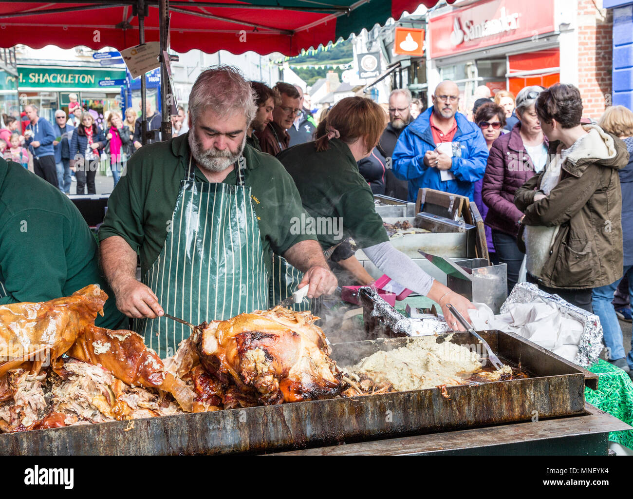 Carving roast port at market stall in street, Abergavenny Food Festival, Wales, UK Stock Photo