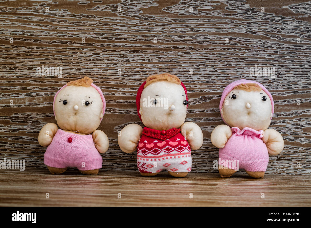 Handmade colorful puffy dolls with knitted dress on brown 