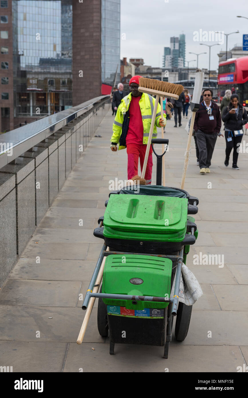 a street cleaner working on london bridge in central london with a