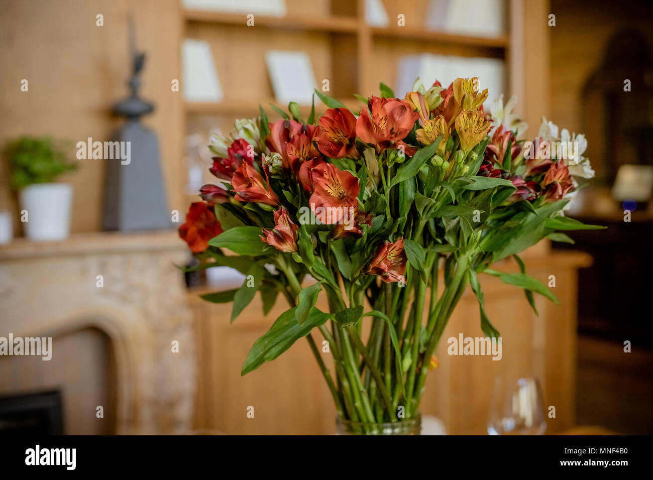 Beautiful bouquet of colorful flowers,Alstroemeria.Lily of the Incas, gorgeous red, orange white alstroemeria bouquet, fresh bright flowers with yellow centers in vase. Home decoration Stock Photo