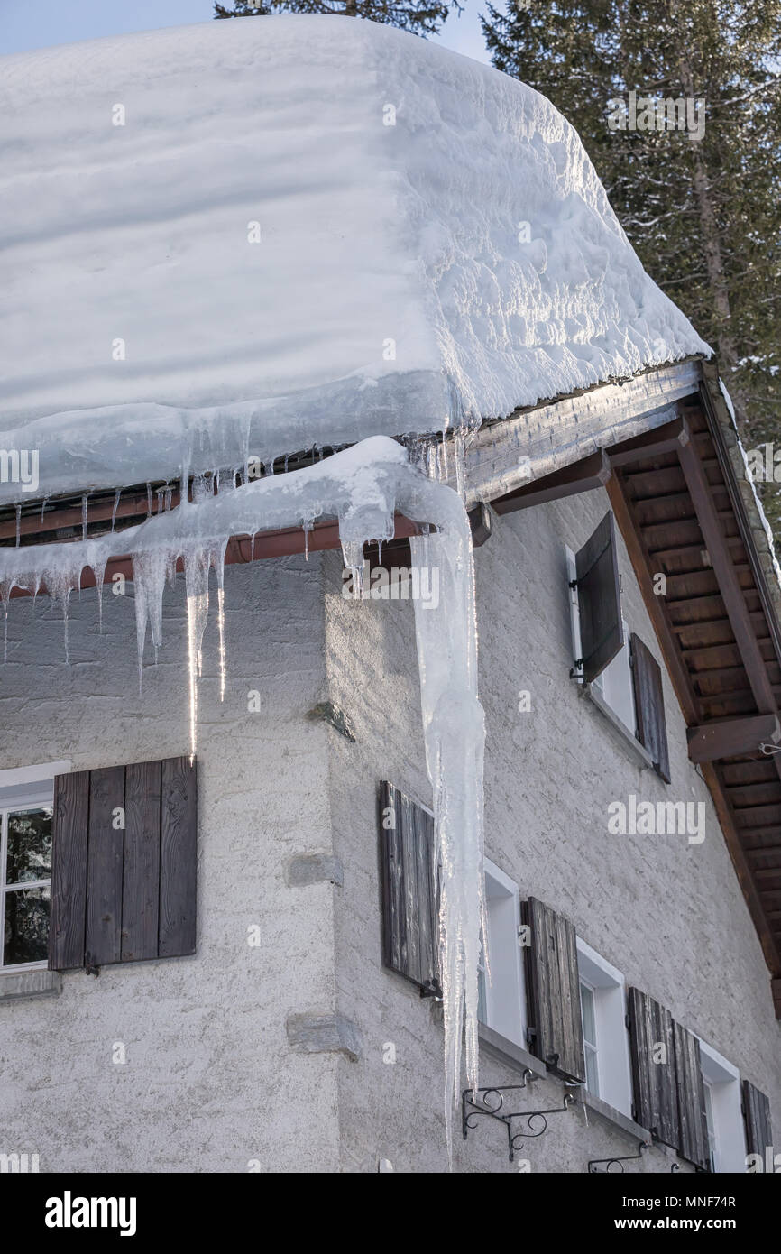 heavy snow on rooftop with icicles Stock Photo
