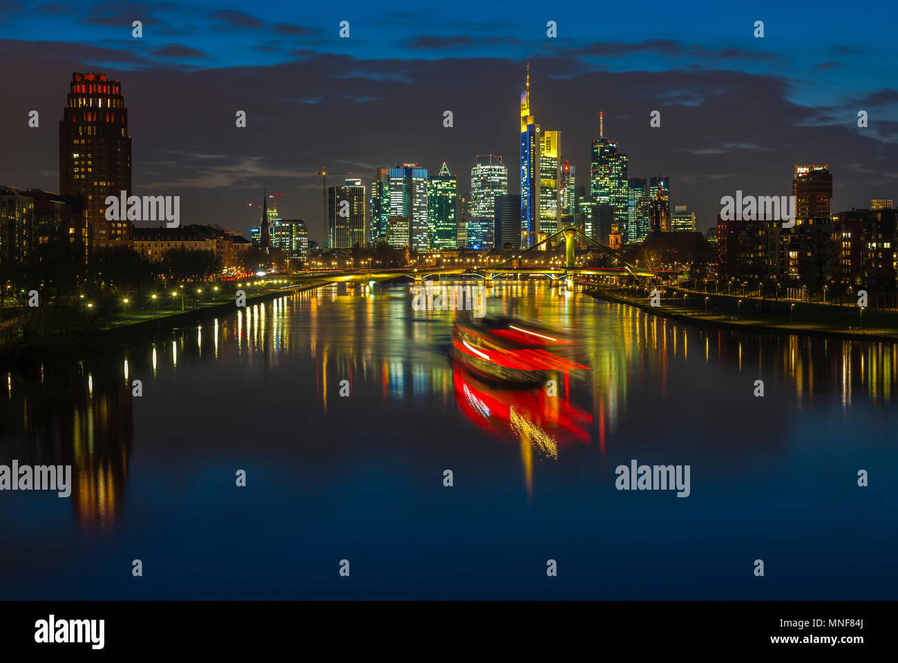 Trail of light from boat in front of skyline, blue hour, Osthafen, Frankfurt am Main, Hesse, Germany Stock Photo