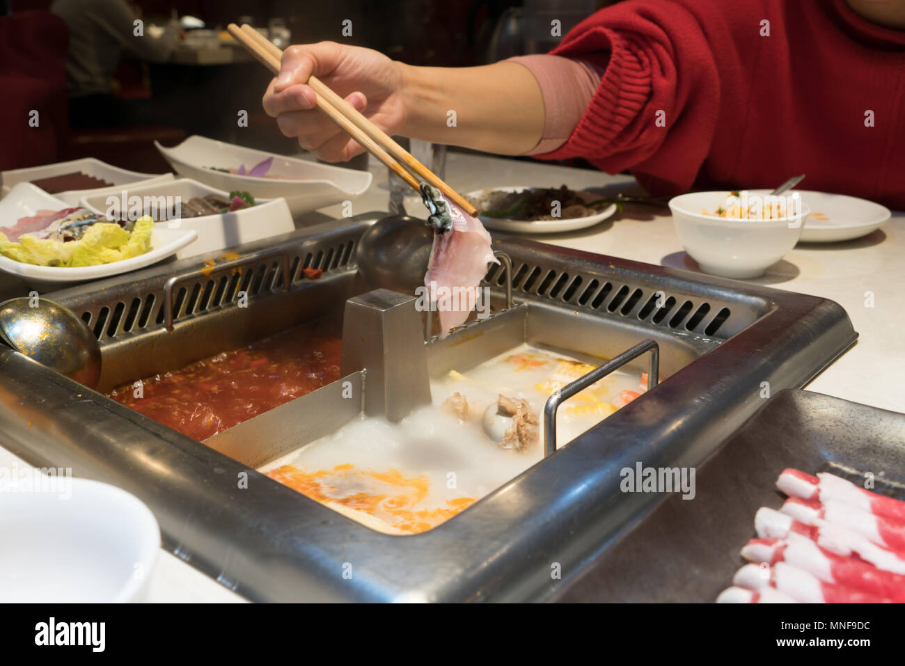 a red shirt women is cooking the Chinese shabu hotpot Stock Photo Alamy