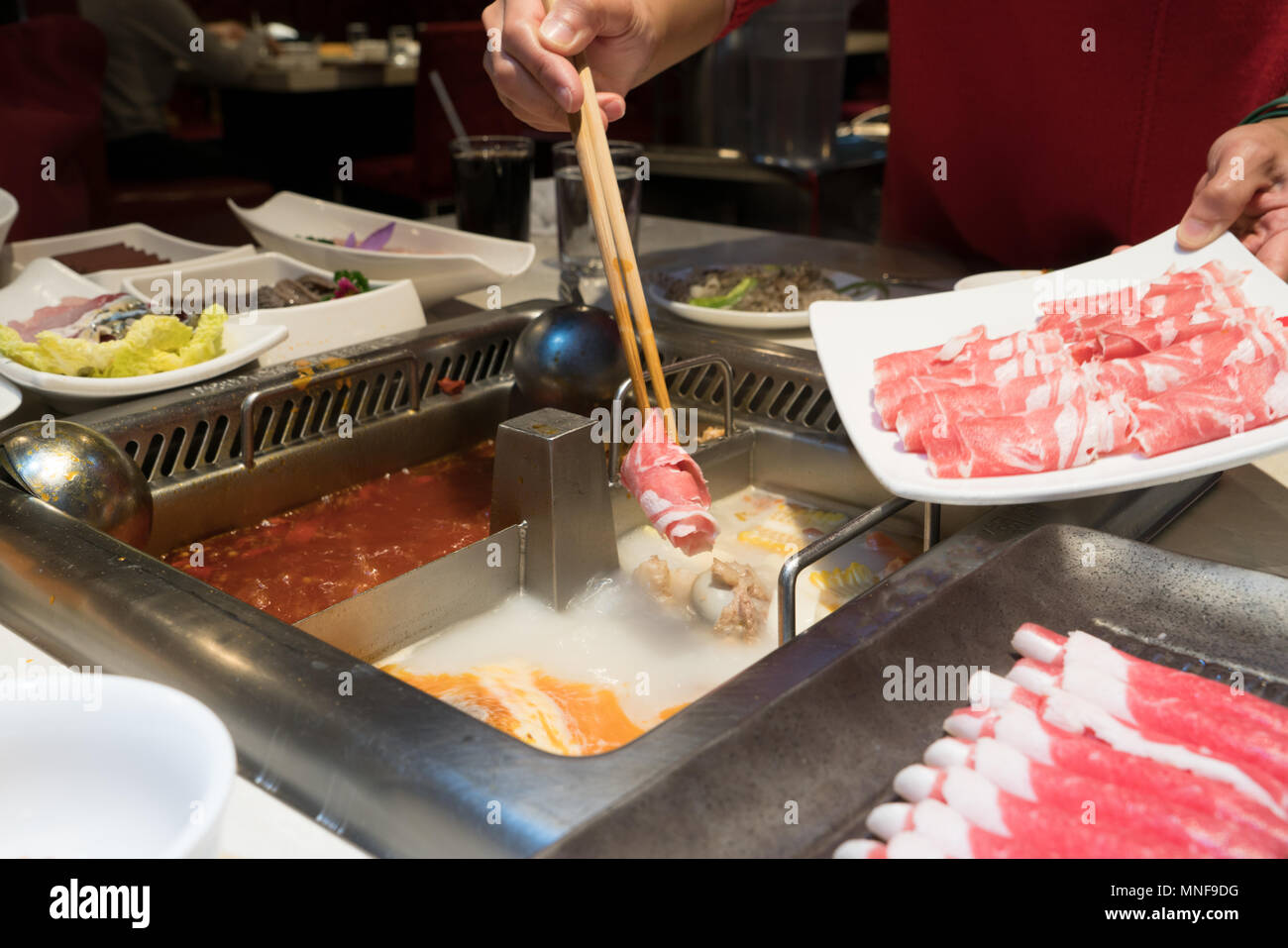 a red shirt women is cooking the Chinese shabu hotpot Stock Photo Alamy