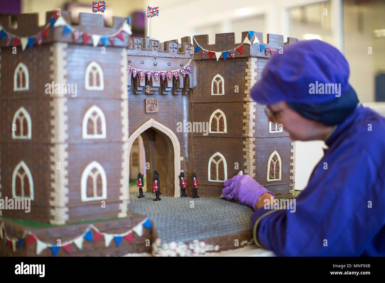 A chocolatier pipes the finishing touches onto the front of Windsor Castle at Cadbury World in Birmingham, which is made entirely out of chocolate and includes the Henry VIII gate with a hand-piped picture of St George's Chapel visible through it, ahead of the royal wedding this weekend. Stock Photo