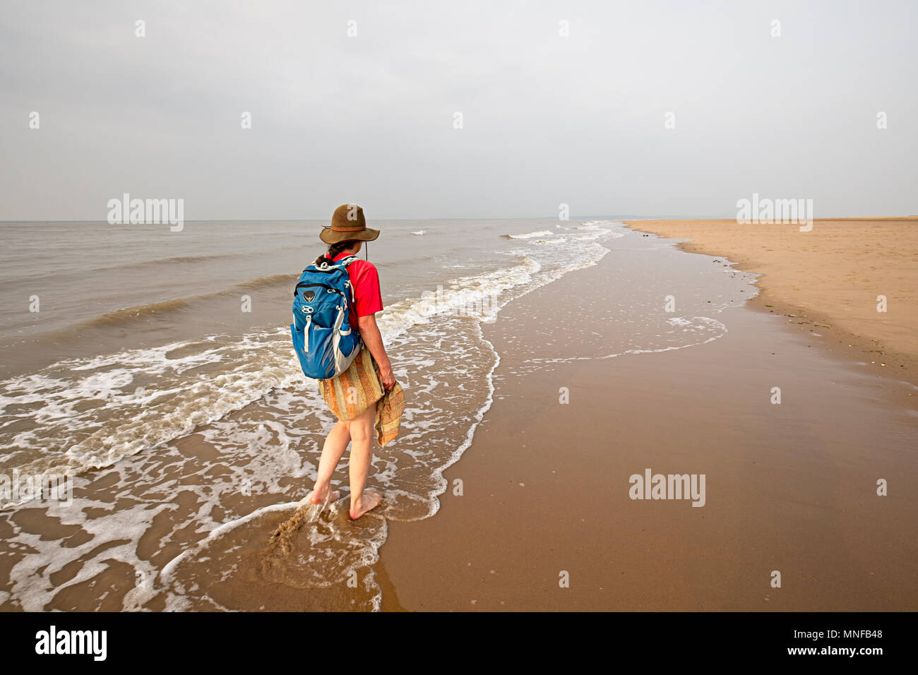 Womasn walking in shallows at Point of Ayr, Flintshire, Wales, UK, the northernmost point in Wales Stock Photo