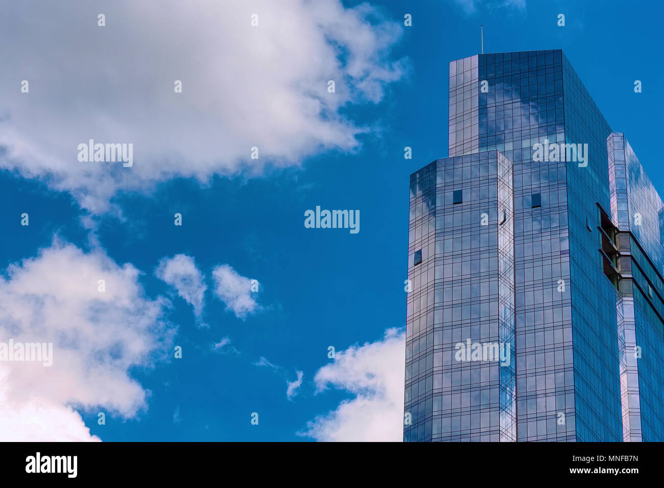 Boston, Massachusetts, USA - September 14, 2016:The top half of the Millennium Tower reflects the blue sky and white clouds. Stock Photo