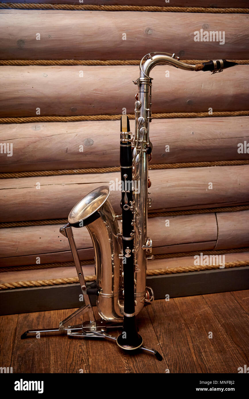 Saxophone and on a stand against the wall of logs Stock Photo