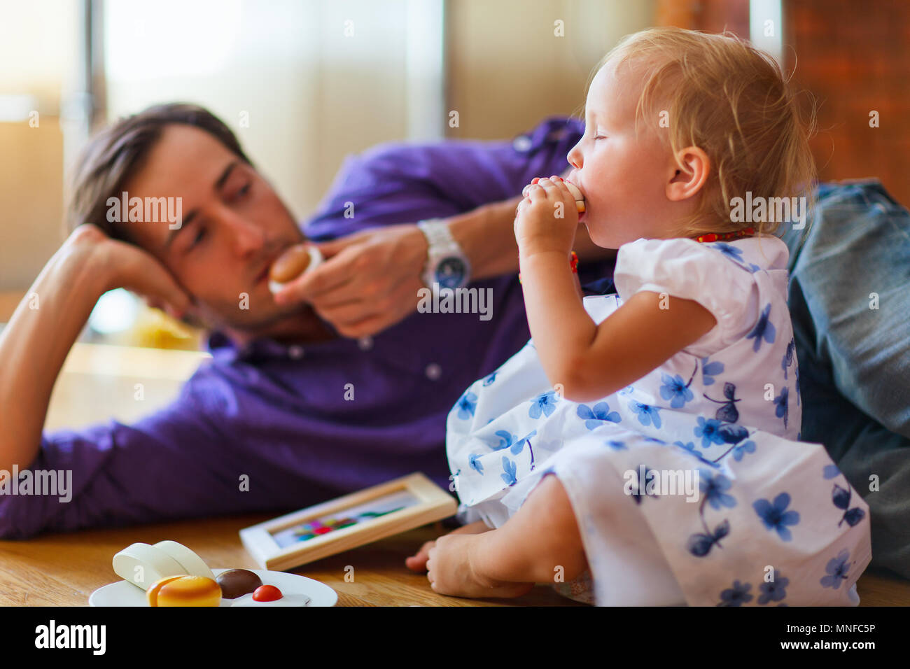 Happy father and his adorable little daughter playing together at home ...