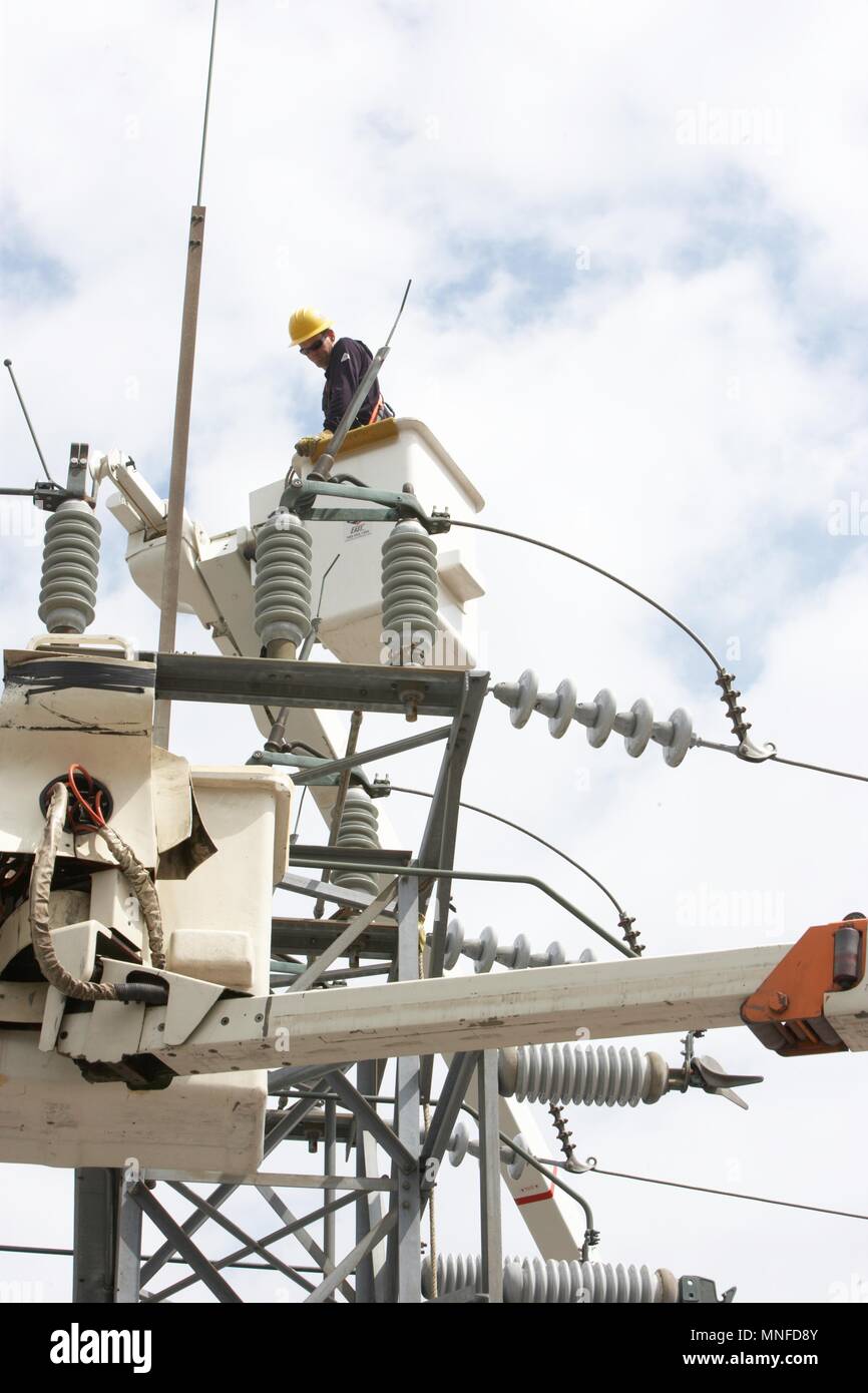 Utility company line man working from a bucket lift to repair and