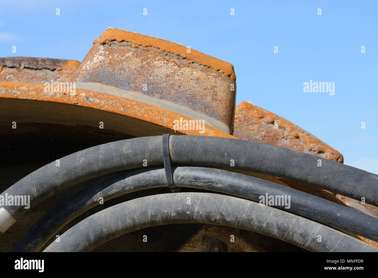 Close up of sheep foot roller compaction road construction and repair machinery against blue sky Stock Photo