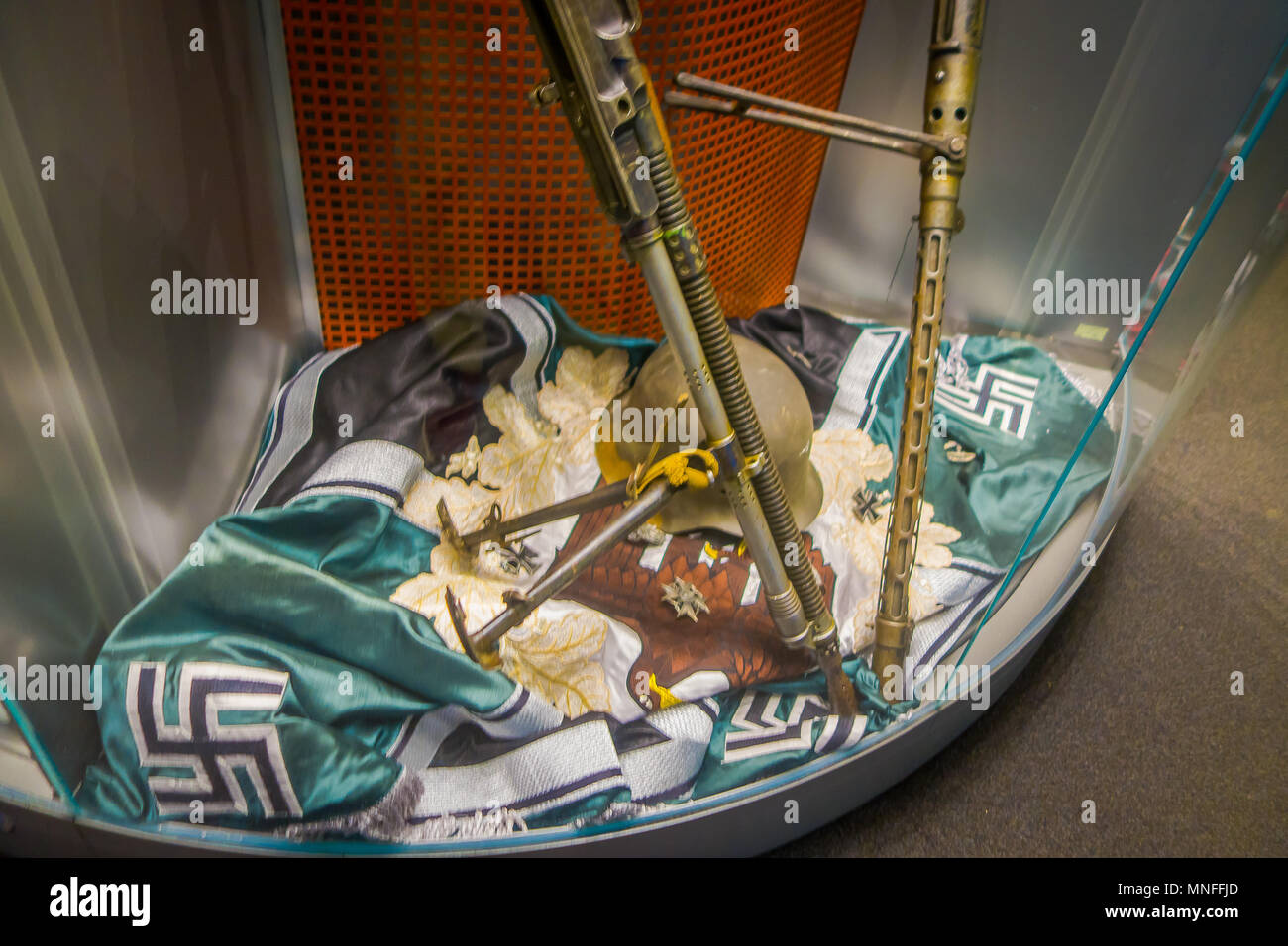 BELARUS, MINSK - MAY 01, 2018: Close up of helmet and gun over a Hakenkreuz swastika nazi sign over a green brand inside of State Museum of the Great Patriotic War of the museum in Minsk Stock Photo