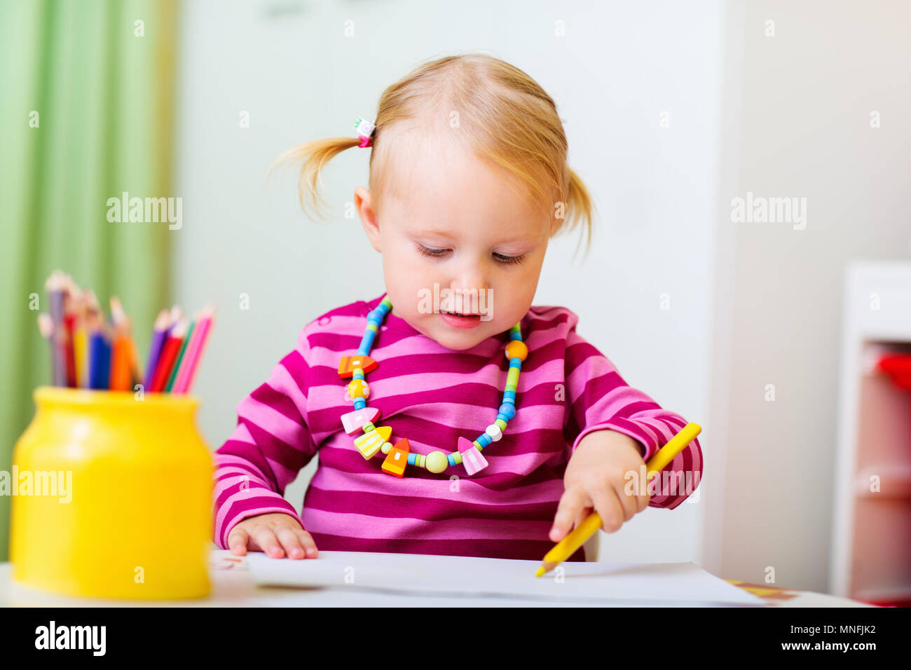 Adorable happy toddler girl drawing with coloring pencils at ...