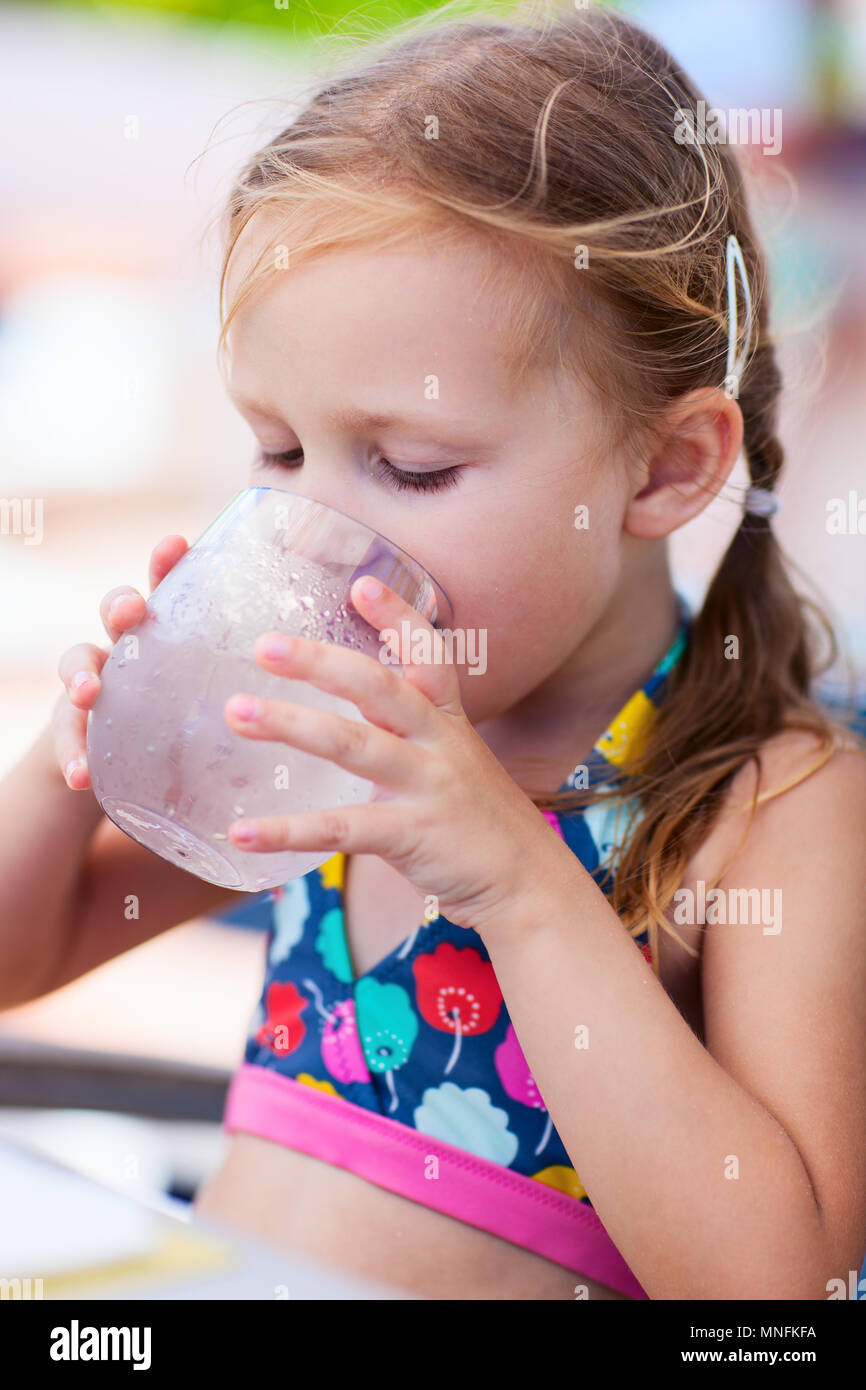 Adorable little girl drinking water from a glass Stock Photo