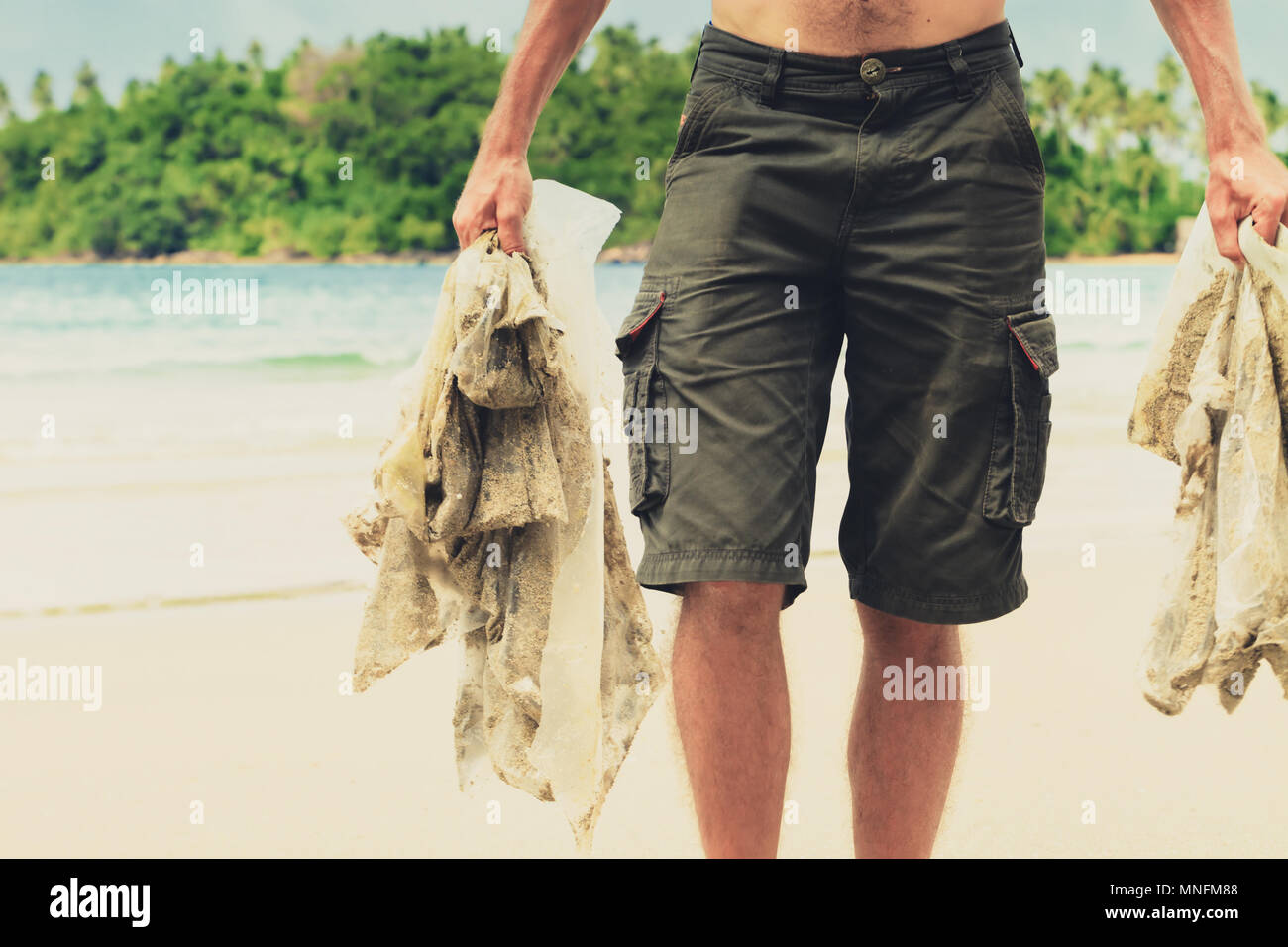 People clean beach from plastic debris. Concept save planet and nature Stock Photo