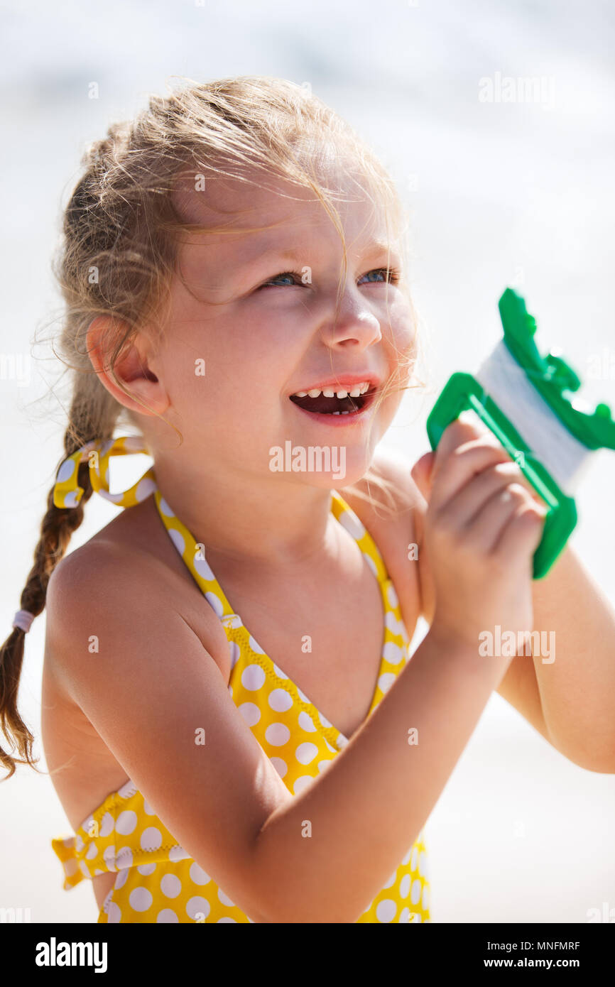 Close up of little girl flying a kite at beach Stock Photo