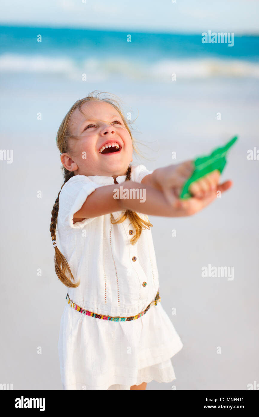Close up of little girl flying a kite at beach Stock Photo