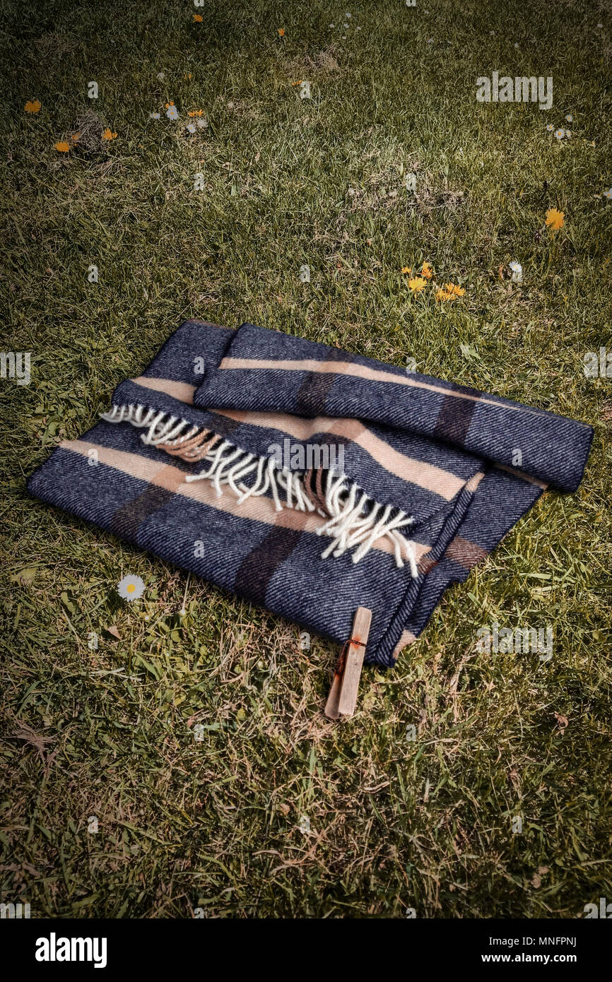 Woollen scarf with single clothes peg on the ground Stock Photo