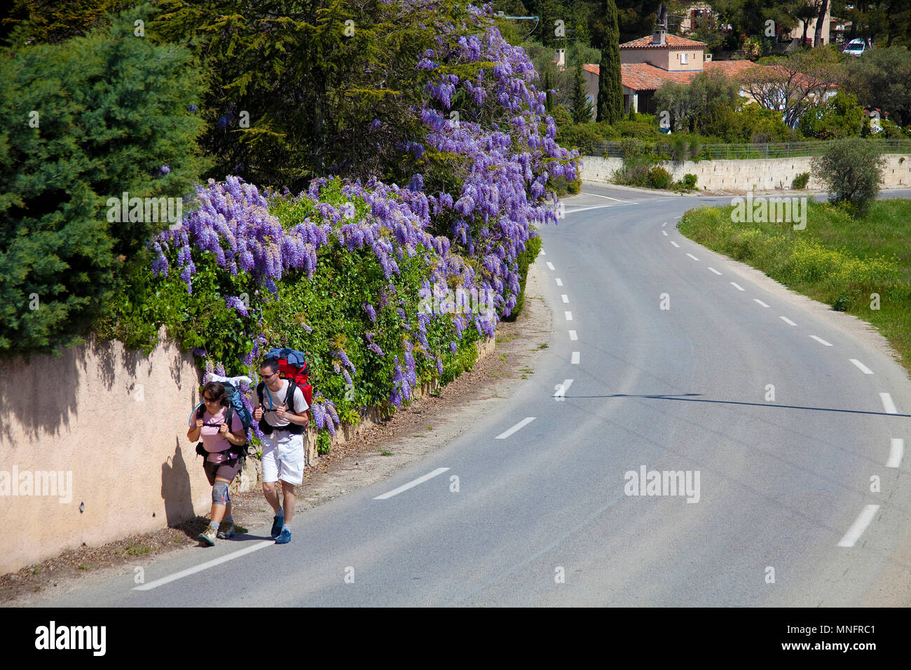 Two backpacker leaving the village La Cadiere d'Azur, Département Var, Provence-Alpes-Côte d’Azur, South France, France, Europe Stock Photo