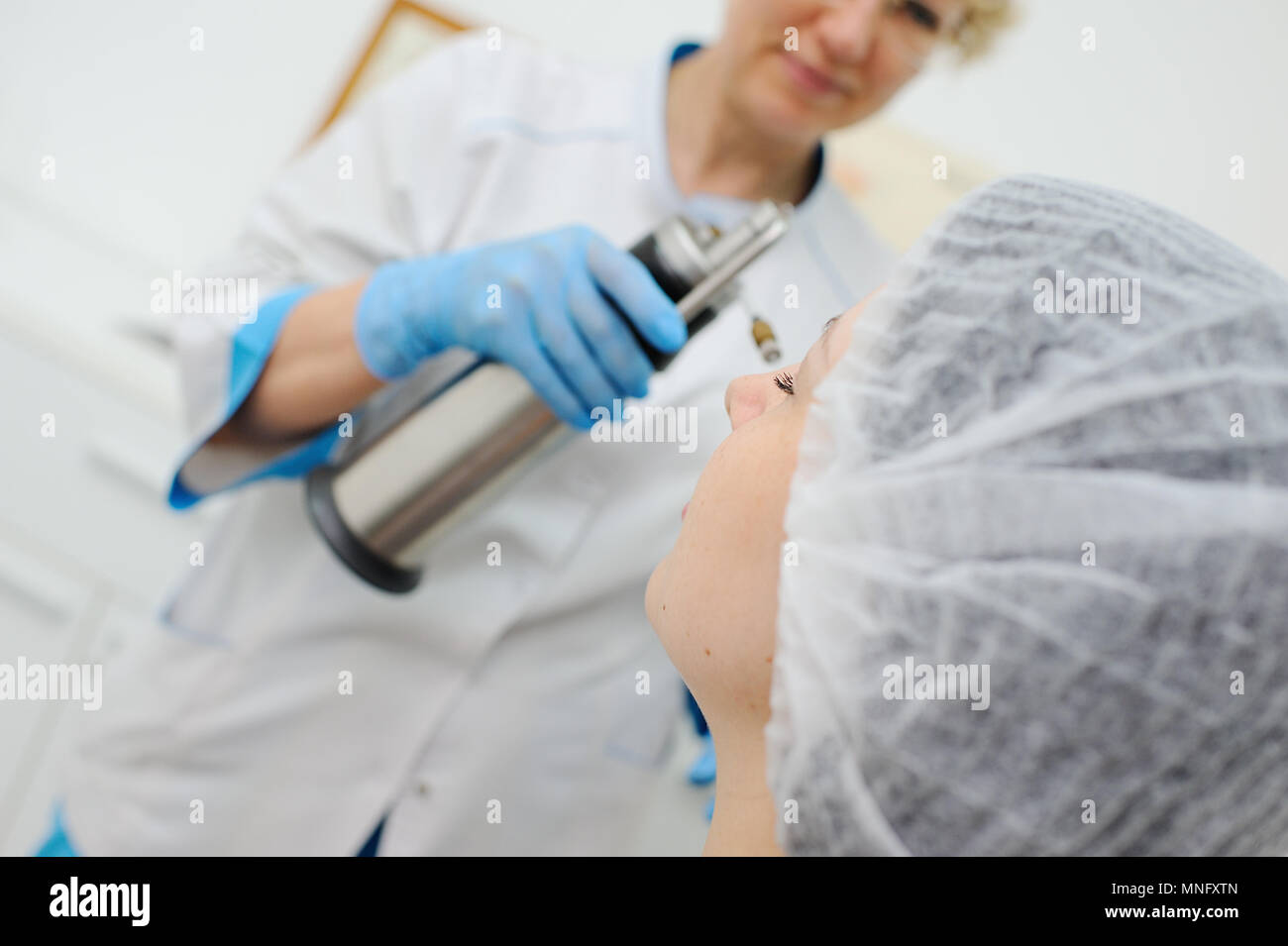 Doctor makes the patient Cryomassage Stock Photo