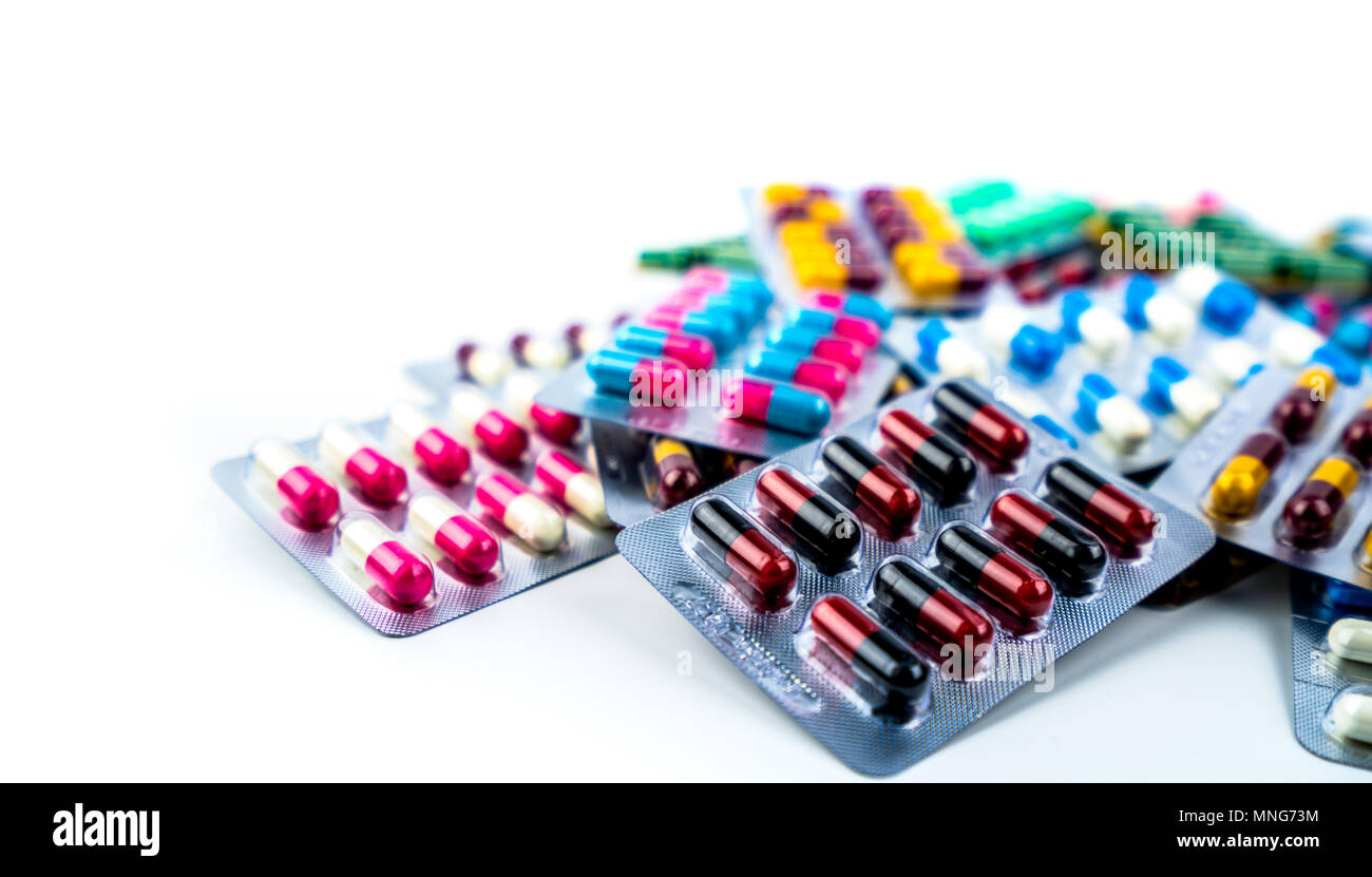 Heap of antibiotic capsule pills in blister pack isolated on white