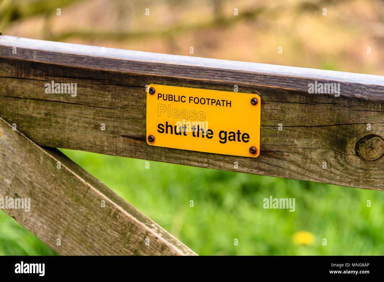 Public Footpath Please Shut The Gate sign, on a wooden gate. May 2018. Stock Photo