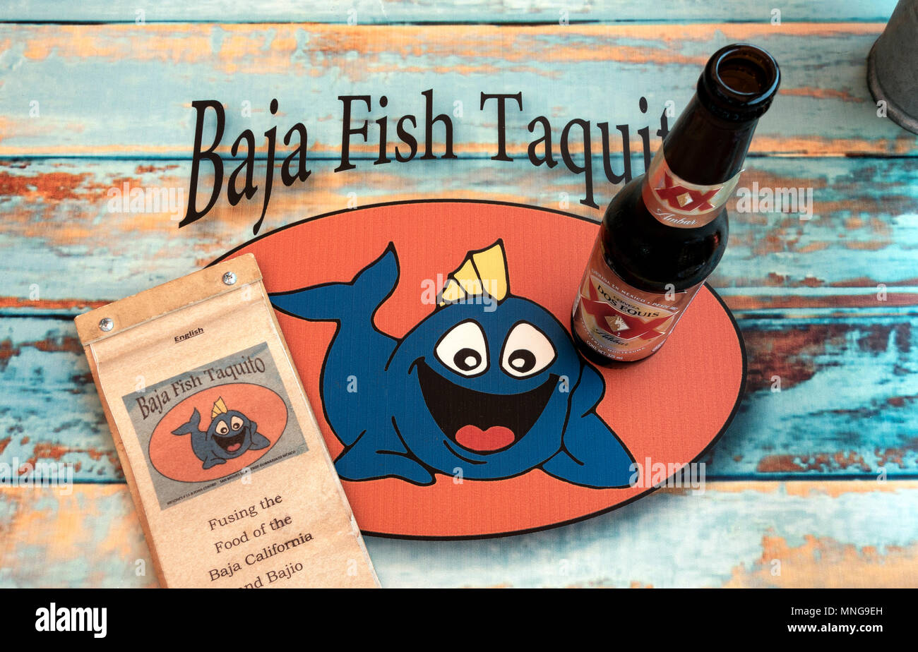 The menu and a bottle of Dos Equis Amber beer on a table at Baja Fish