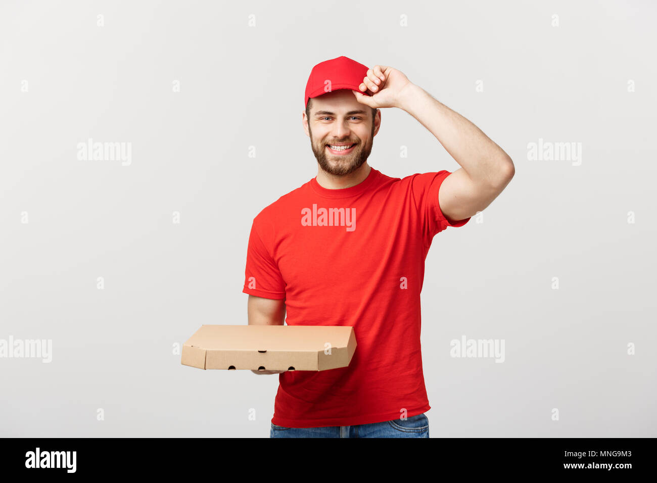 Delivery Concept: Young haapy caucasian Handsome Pizza delivery man holding pizza boxes isolated over grey background Stock Photo