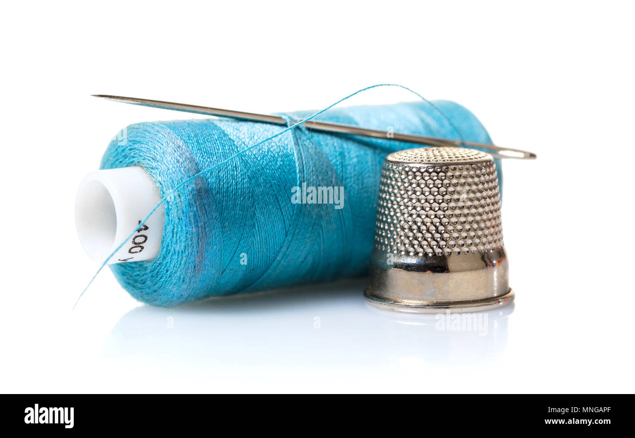 Sewing items - thimble, needle, measuring tape, spools of blue thread,  including pins. Blue fabric for sewing on background Stock Photo - Alamy