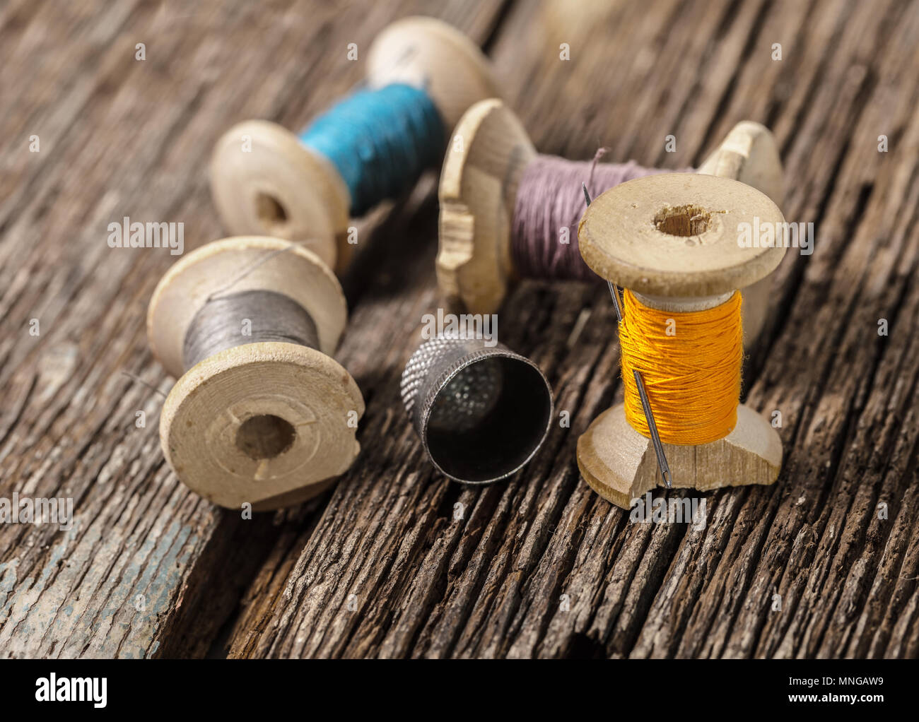 colored threads and thimble on wooden background Stock Photo