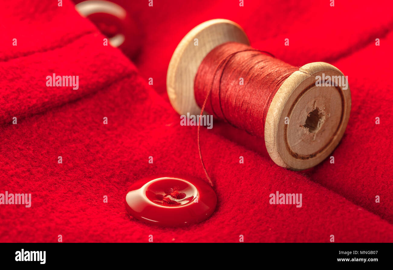red thread with buttons on woolen fabric background Stock Photo - Alamy