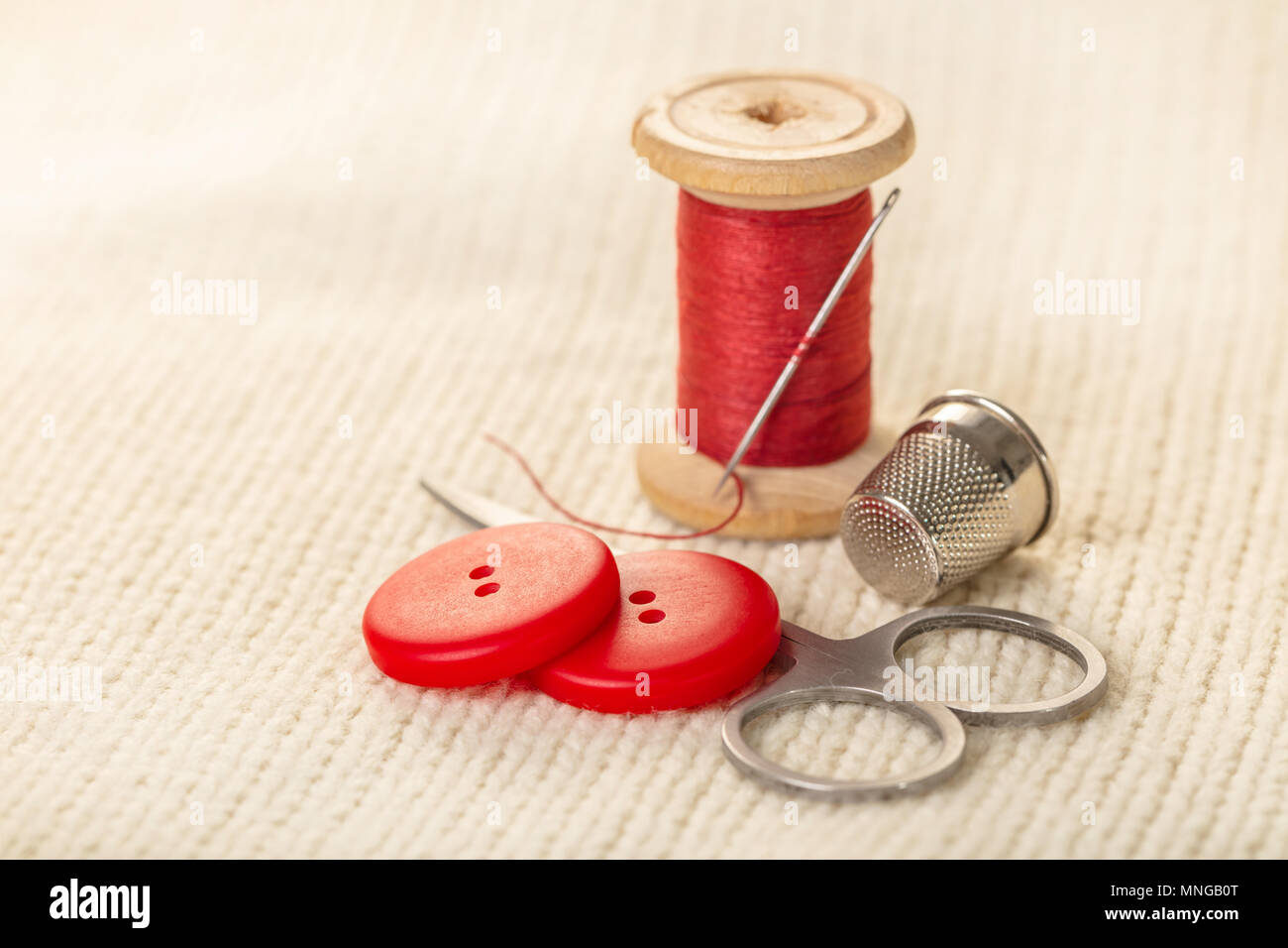 coils of colored thread on white knitted fabric Stock Photo - Alamy