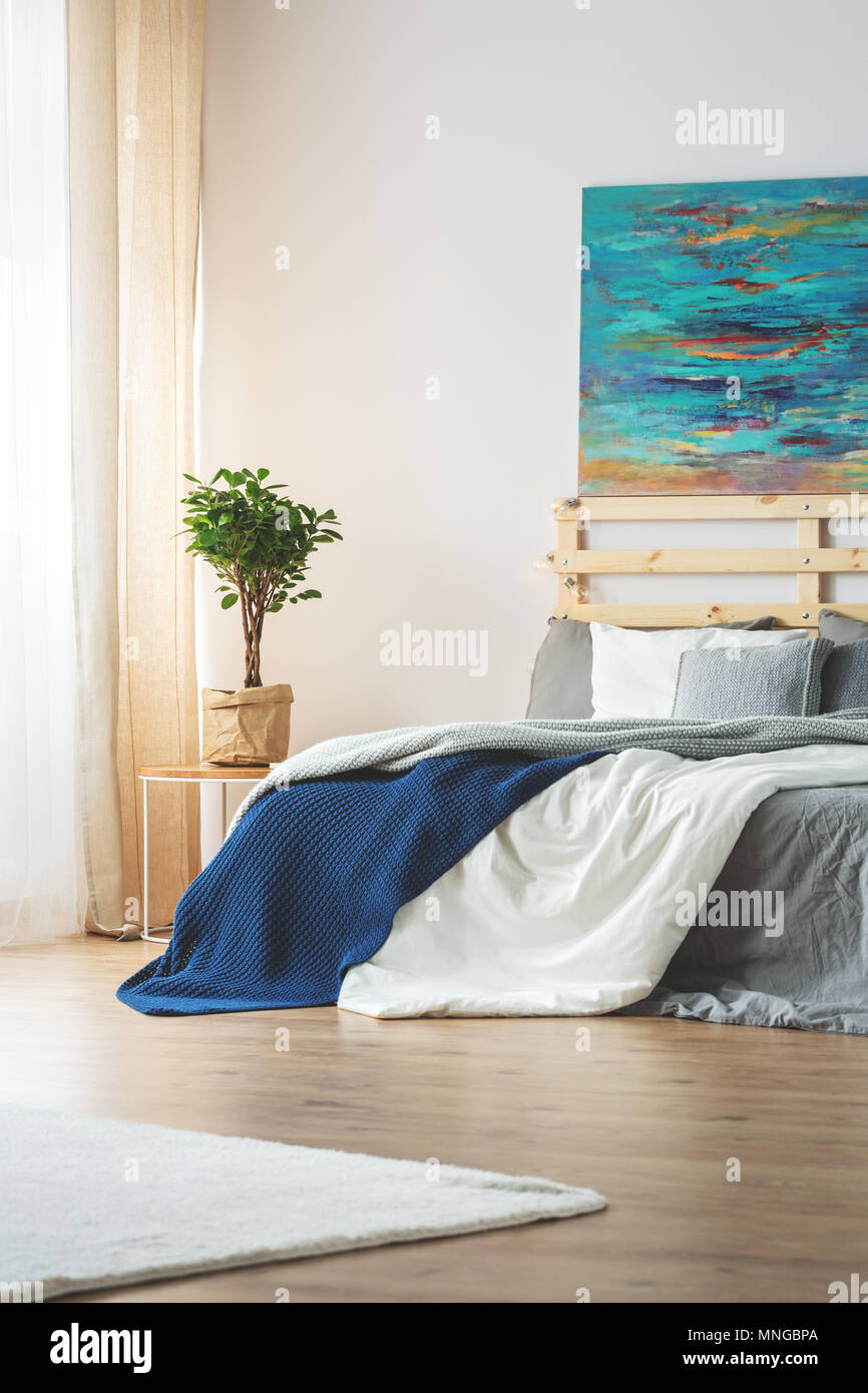 Modern bedroom with blue painting above kingsize bed Stock Photo Alamy