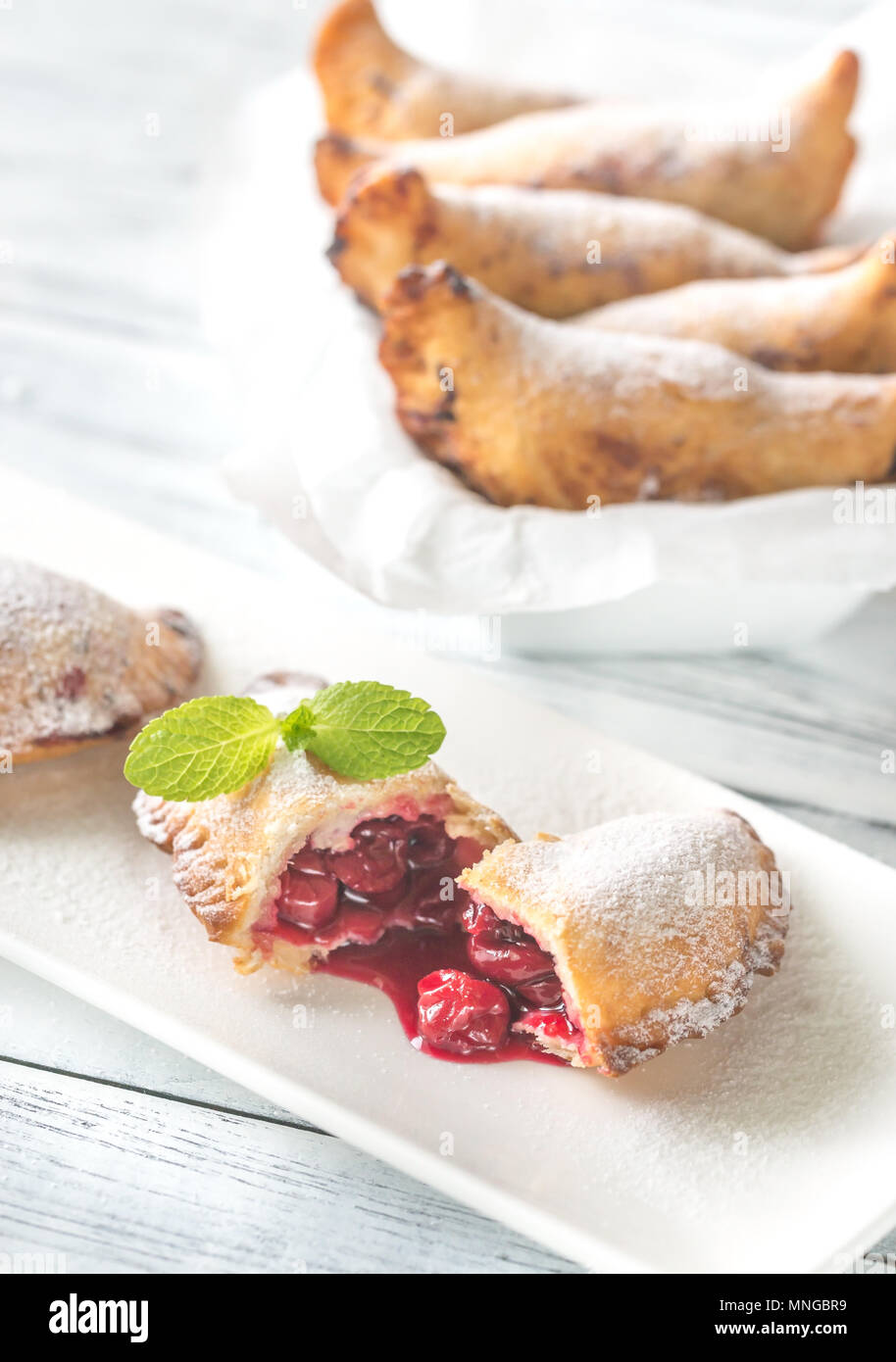 Cherry empanadas on the white plate Stock Photo Alamy