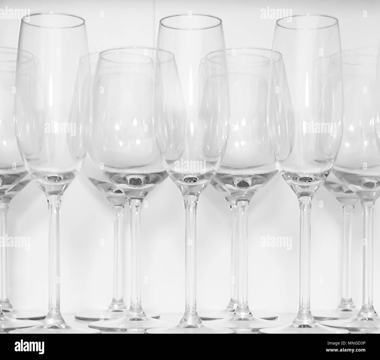 Wine glasses standing in rows on a white shelf Stock Photo