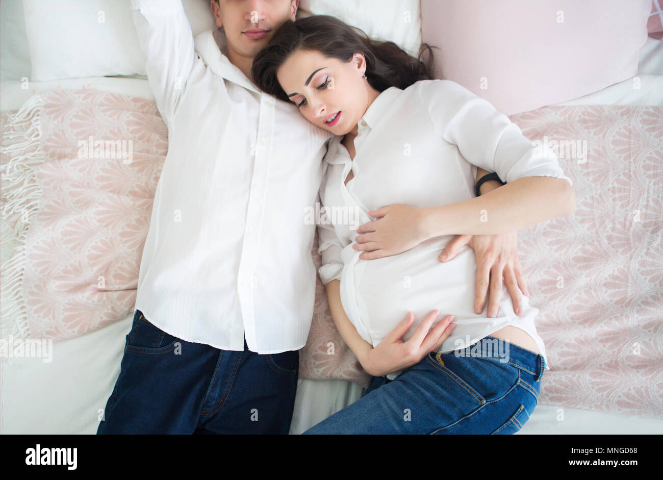 Portrait of the pregnant woman and young man together indoors Stock ...
