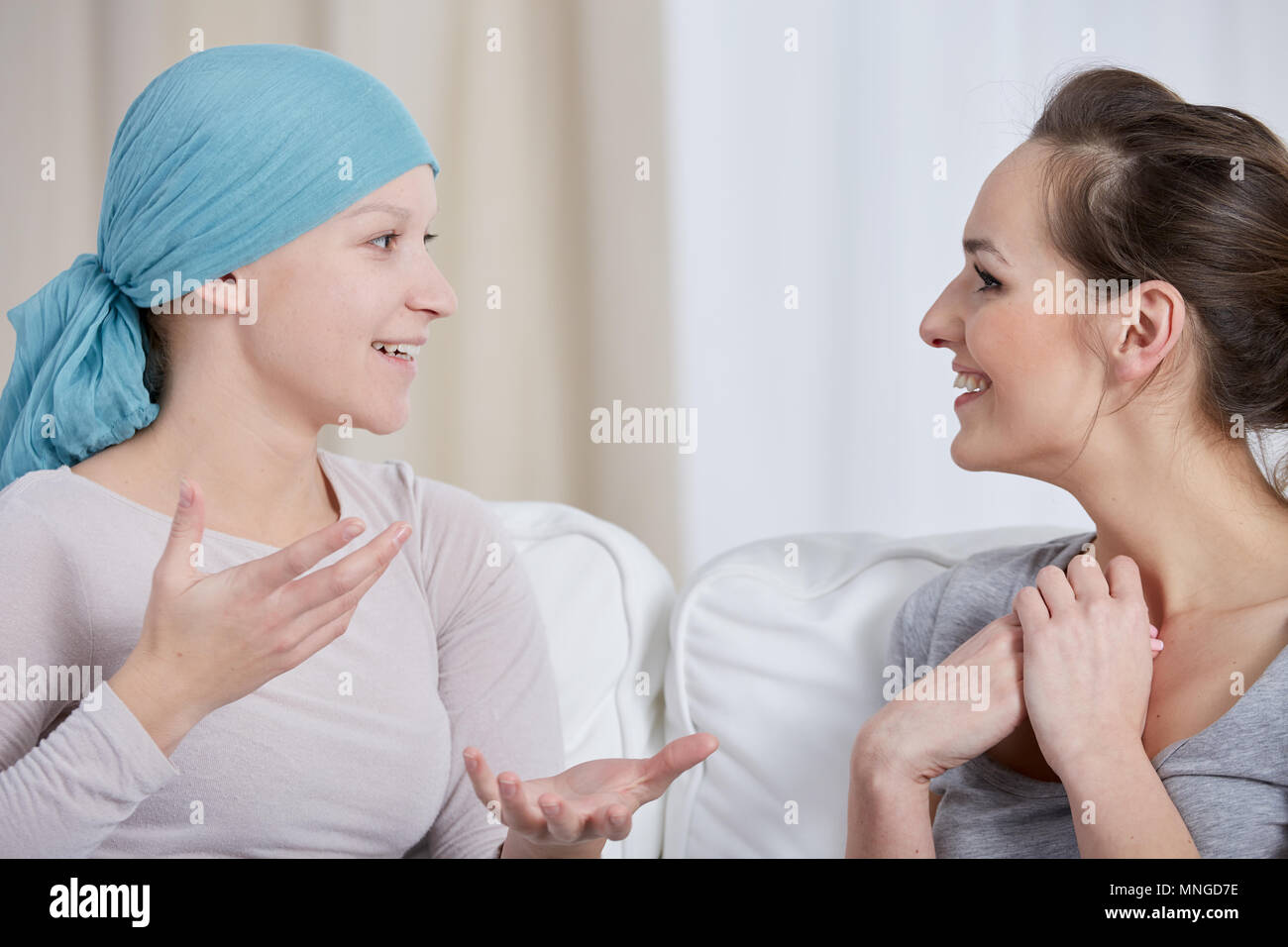 Young cancer woman wearing headscarf, talking with friend Stock Photo