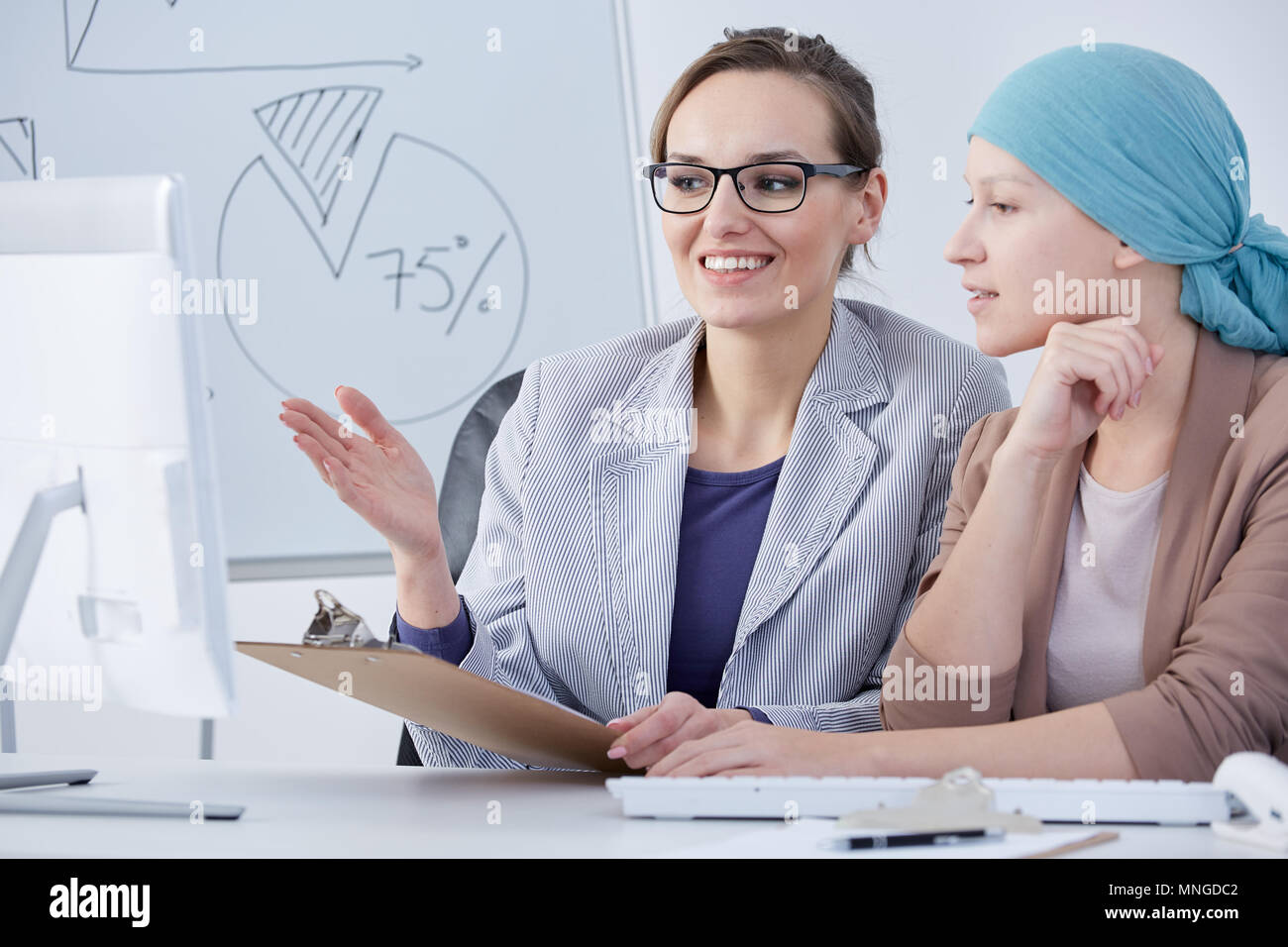 Cancer woman working at office, talking with her workmate Stock Photo