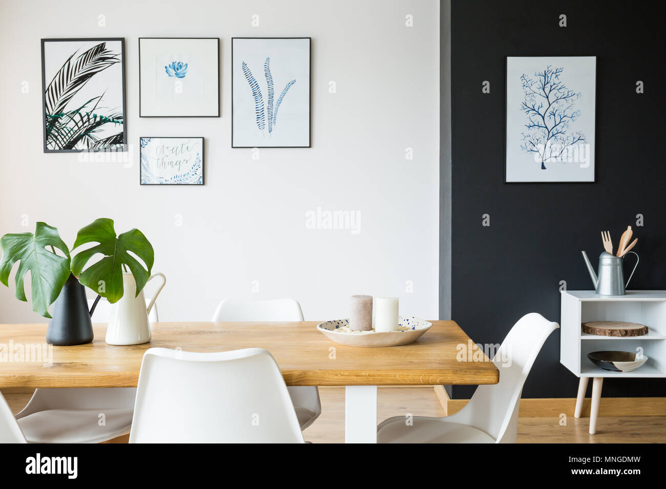 Black and white dining room with wooden table and posters Stock Photo