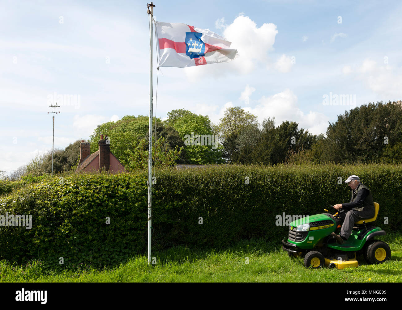 Elderly man using ride-on lawn mower, Bawdsey, Suffolk, England. Stock Photo