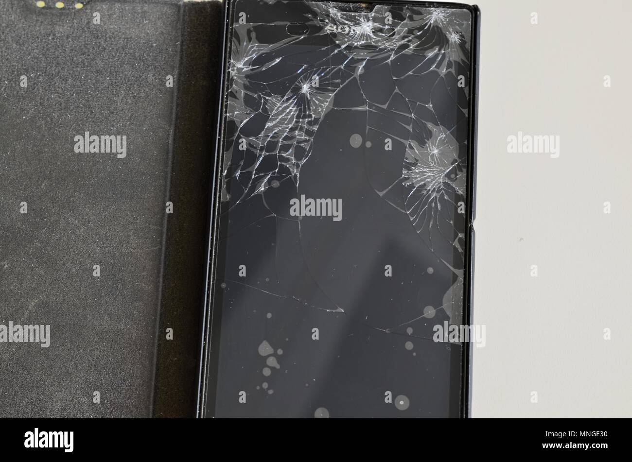 Cellphone screen with broken glass. Non-protecting the protective film glass is a web of glass splinters. Stock Photo